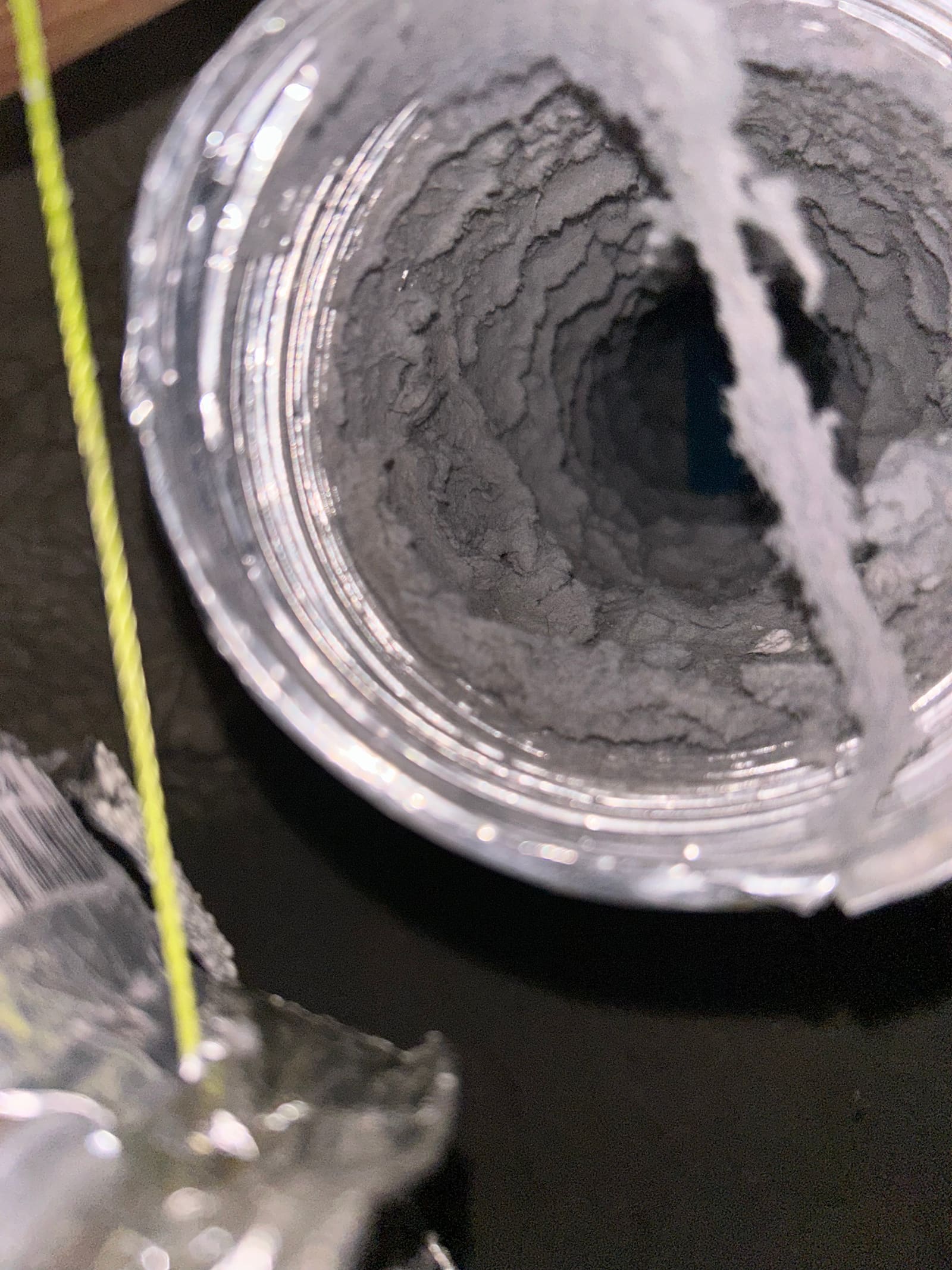 Lint buildup narrowing a flexible dryer duct to a fraction of its original diameter.
