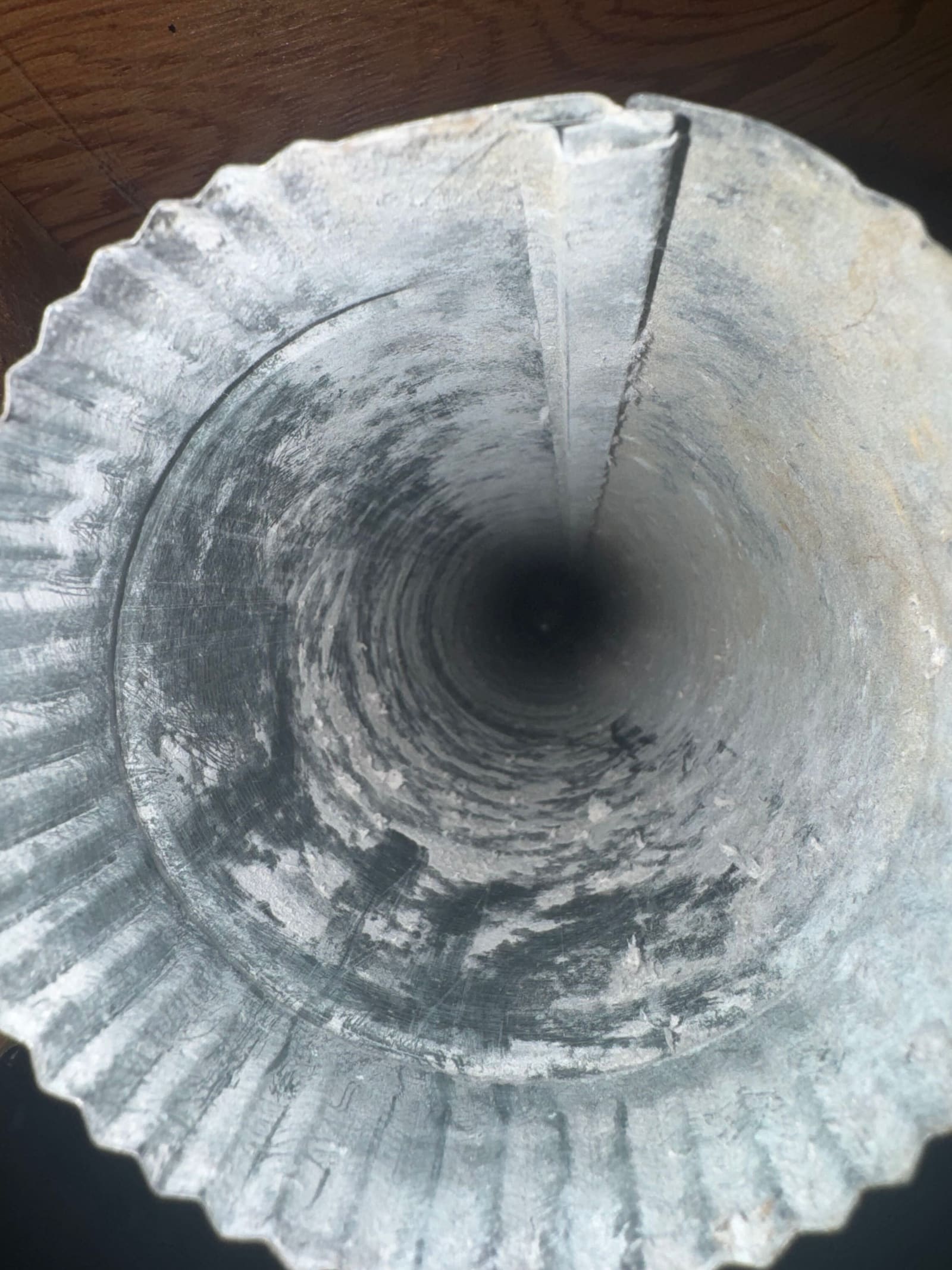 A cleaning brush passing through a dryer duct, with the walls behind it already clear of lint.